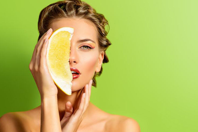 lady holding lemon in front of her face