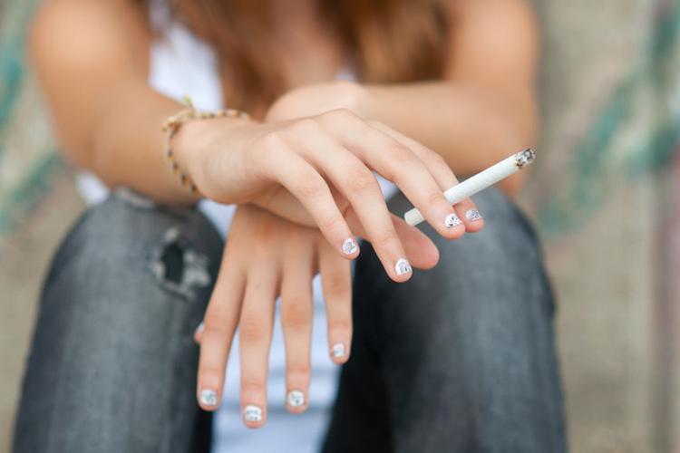 lady holding a cigarette in her hand