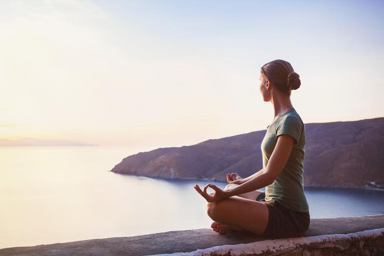 Lady meditating by the coast