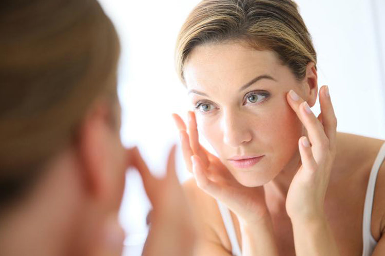 reflection of lady applying skincare 