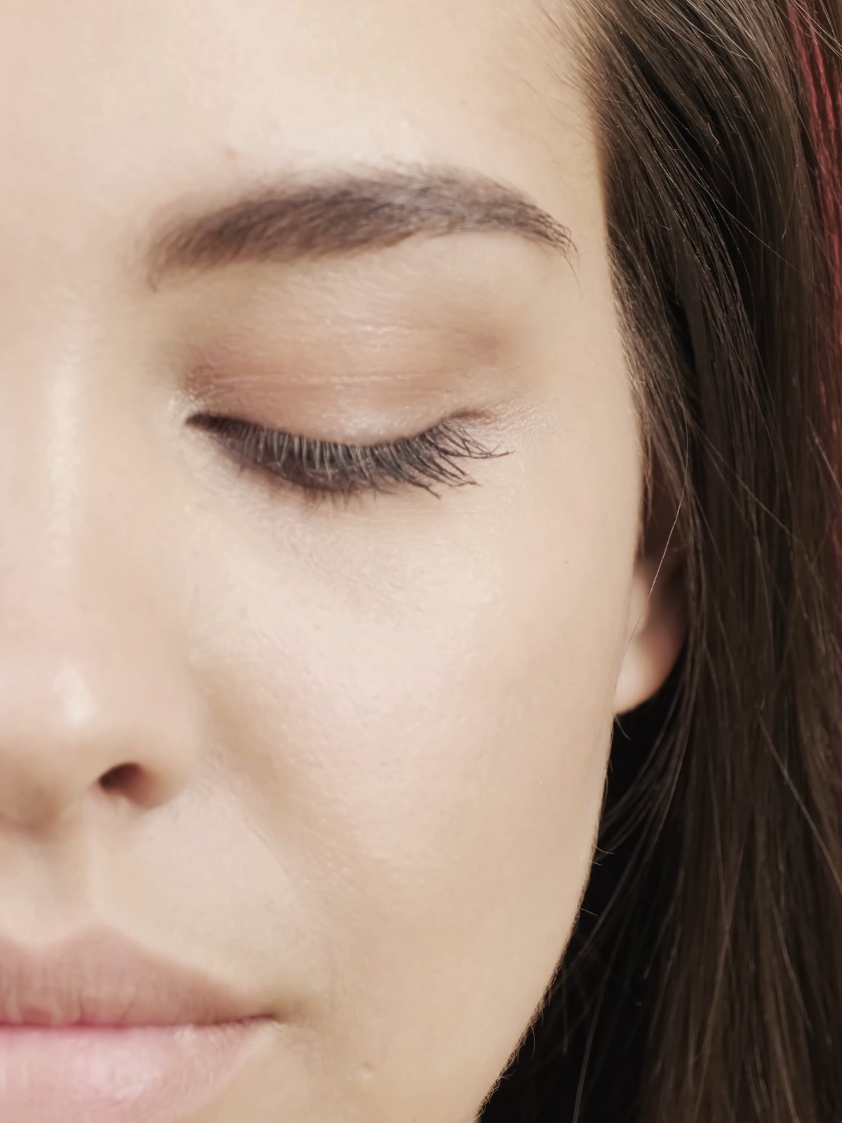 Close-up of a model's face with eyes closed, showing clear, even skin
